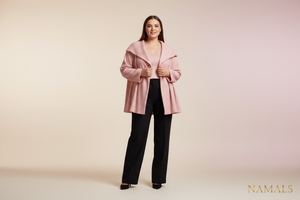 A realistic 4K studio photo of a confident woman weighing around 70 kg, modeling a pink jacket and black pants for the Namals fashion brand. The image should have a clean, elegant background (white or soft pastel), with professional studio lighting that highlights the fabric’s texture and color. The model looks natural, poised, and stylish — reflecting modern, body-positive fashion. The outfit should appear high-quality, feminine, and luxurious, consistent with the Namals aesthetic. Full-body shot, ultra-re